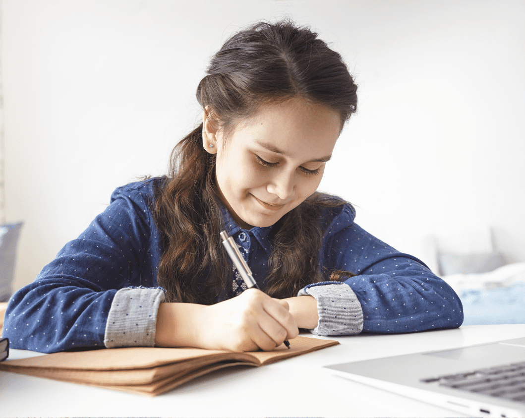 young teen taking notes during online class young teen taking notes during online class