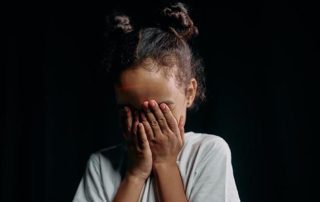 Migraines in children - how neurofeedback can help young girl holding her head in her hands