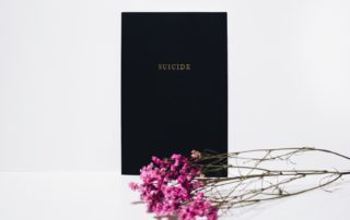 black book with the word suicide on the front with pink flowers
